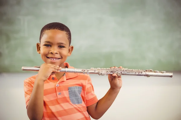 Lächelnder Schüler spielt Flöte im Klassenzimmer — Stockfoto