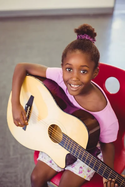Улыбающаяся школьница играет на гитаре — стоковое фото