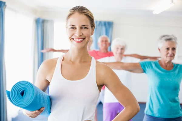 Instructor holding yoga mat — Stock Photo, Image