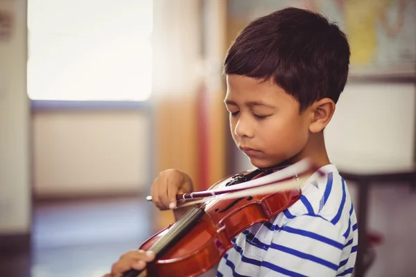 Schoolboy playing violin in classroom — Stock Photo, Image