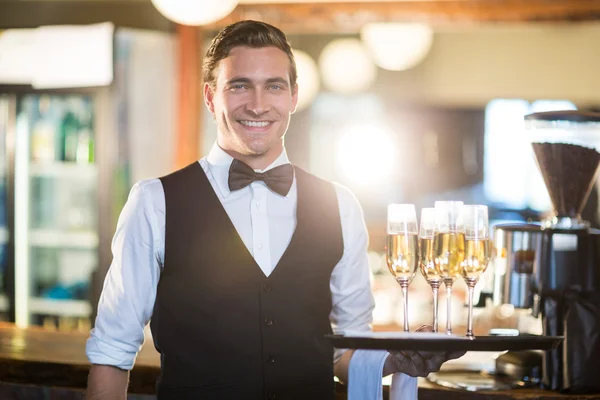 Servitören innehar fack med champagne flöjter — Stockfoto