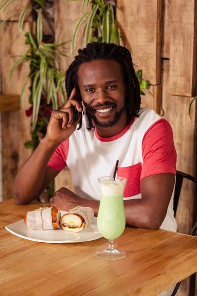 Hipster homem no telefone enquanto come — Fotografia de Stock