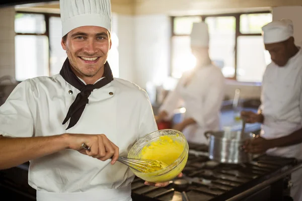 Chef sorridente mescolando pasta — Foto Stock