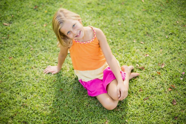 Jeune fille assise sur l'herbe — Photo