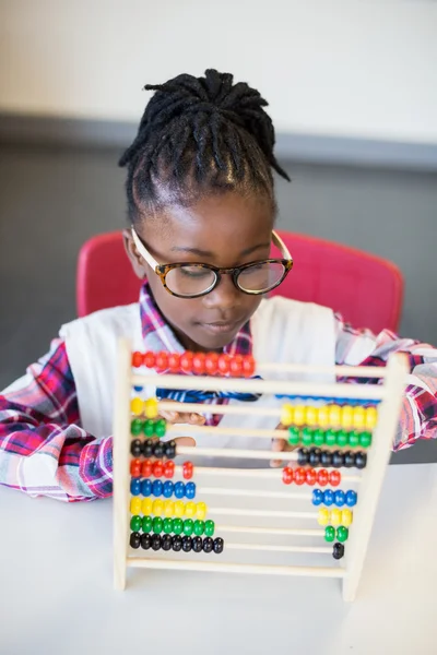 Colegiala usando un ábaco de matemáticas — Foto de Stock