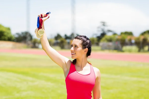 Happy female athlete showing her gold medals — Stock Photo, Image