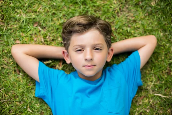 Young boy lying on grass — Stockfoto