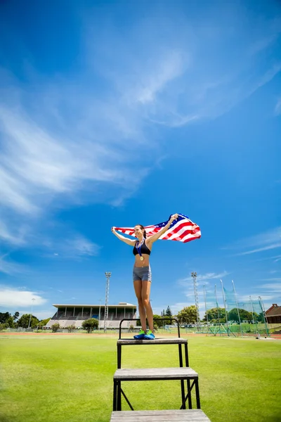 Szczęśliwy, samica sportowiec trzyma się Flaga Amerykańska — Zdjęcie stockowe