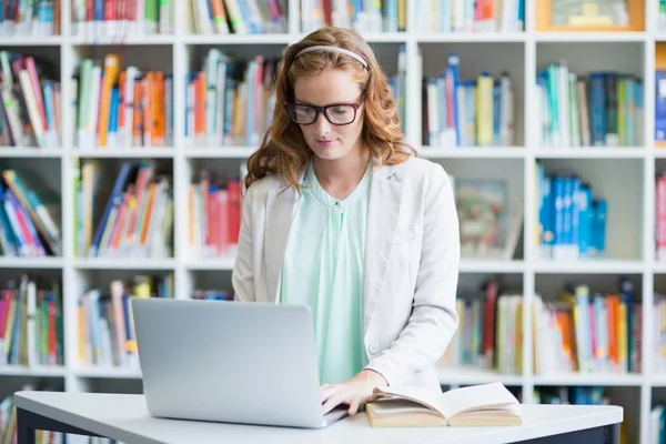 Lärare använder laptop i biblioteket — Stockfoto