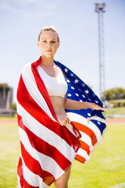 Portræt af kvindelig atlet indpakket i amerikansk flag - Stock-foto