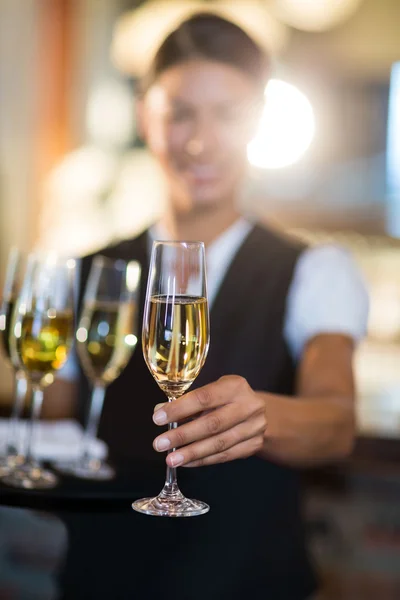 Servitrisen erbjuder ett glas champagne — Stockfoto