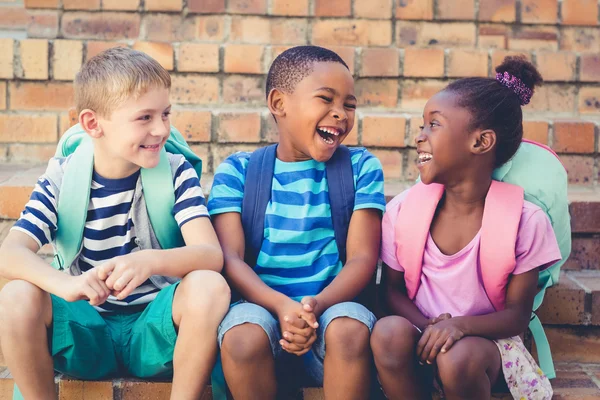 Niños de la escuela sentados juntos en la escalera — Foto de Stock