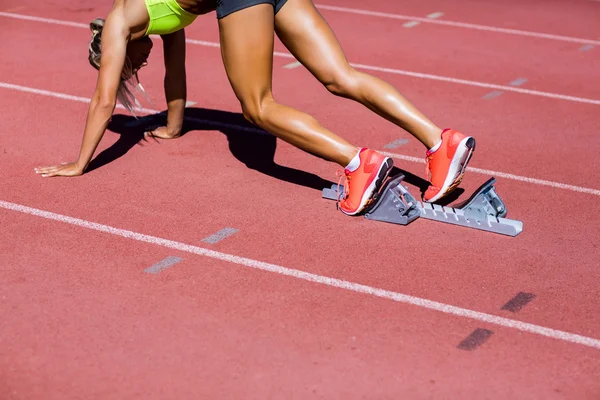 Atleta feminina pronta para correr em pista de corrida — Fotografia de Stock