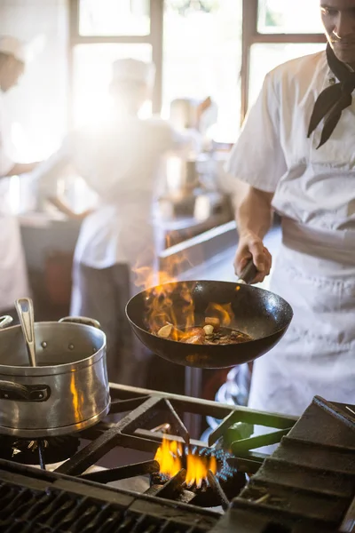 Chef-kok koken in de keuken kachel — Stockfoto