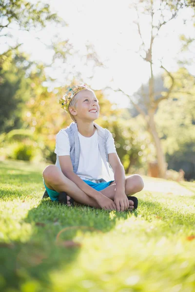 Giovane ragazzo seduto nel parco — Foto Stock