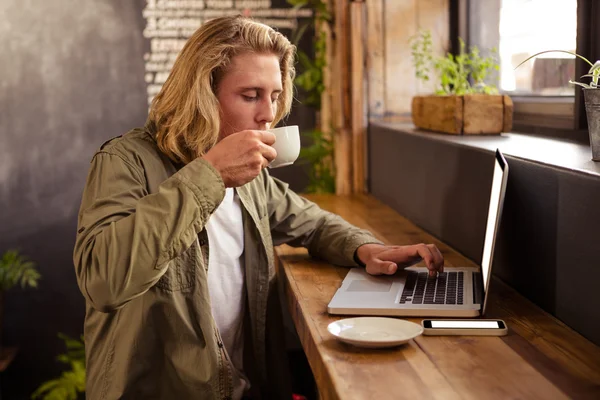 Picie kawy człowiek korzysta z laptopa — Zdjęcie stockowe