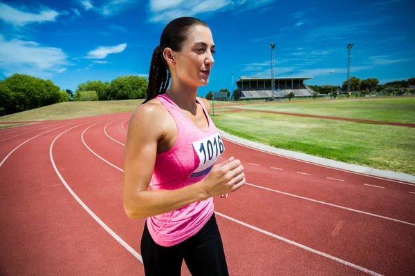 Athlète féminine qui court sur la piste de course — Photo