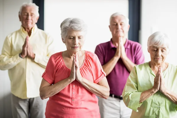 Anziani che fanno yoga con gli occhi chiusi — Foto Stock