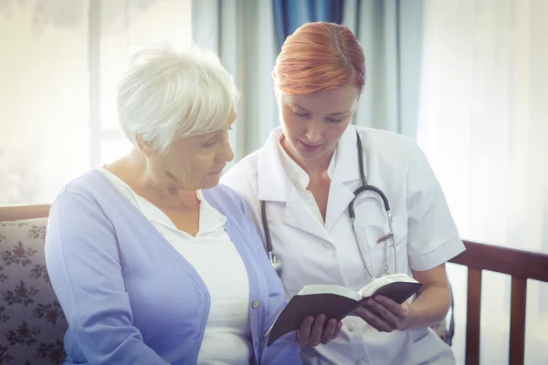 Médico e paciente lendo um livro — Fotografia de Stock