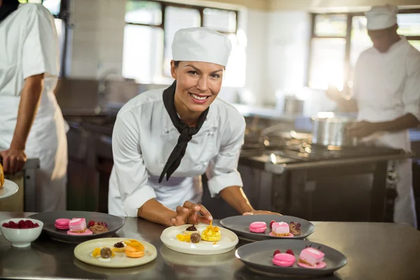 Kvinnliga kock avslutande dessert tallrikar — Stockfoto