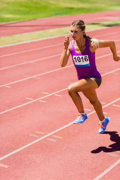 Atleta femenina corriendo en la pista de carreras — Foto de Stock