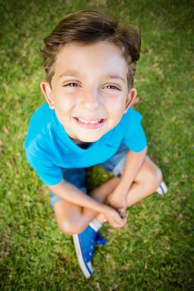 Menino sentado na grama — Fotografia de Stock