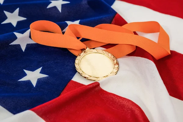 Primer plano de la medalla de oro en la bandera americana — Foto de Stock