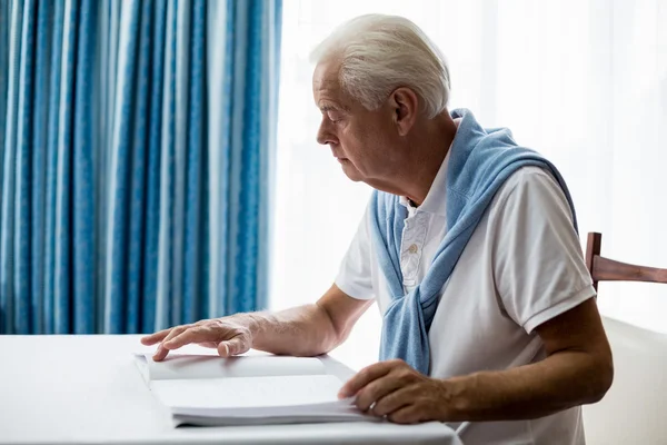Senior man using braille to read — Stock Photo, Image