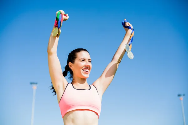 Female athlete showing her gold medals — Stock Photo, Image