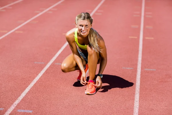 Retrato de atleta feminina amarrando os atacadores dos sapatos — Fotografia de Stock