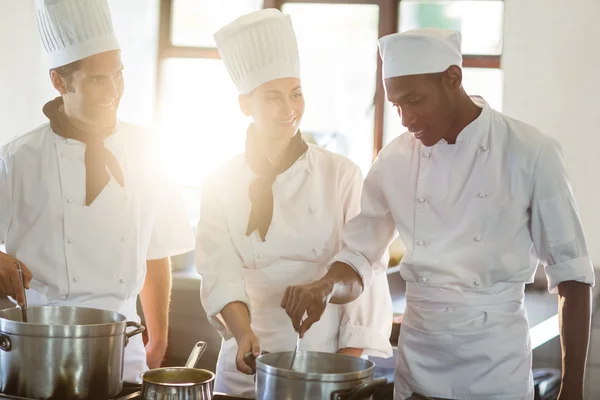 Chefe de cozinha trabalhando com colegas — Fotografia de Stock