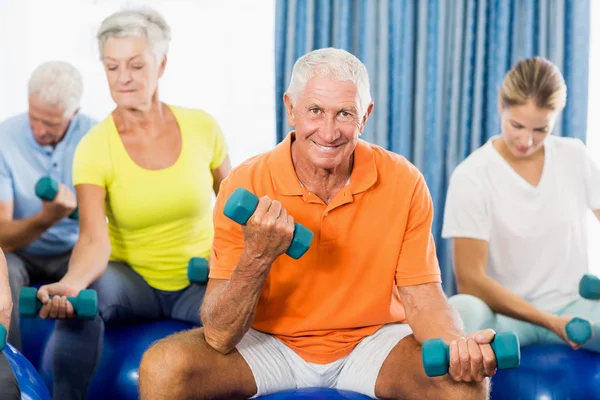 Seniors using exercise ball and weights — Stock Photo, Image