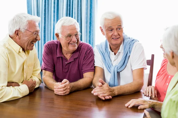 Personas mayores hablando en la mesa — Foto de Stock