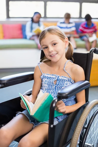 Disabled school girl reading book — Stock Photo, Image