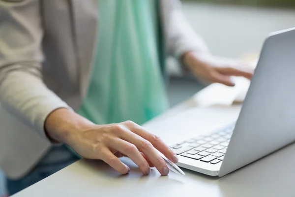 Lärare använder laptop i biblioteket — Stockfoto