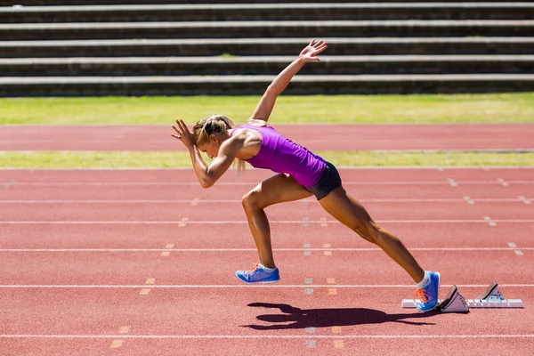 Atleta feminina correndo na pista de corrida — Fotografia de Stock