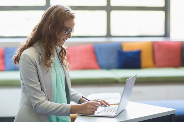 Lehrer benutzt Laptop in Bibliothek — Stockfoto