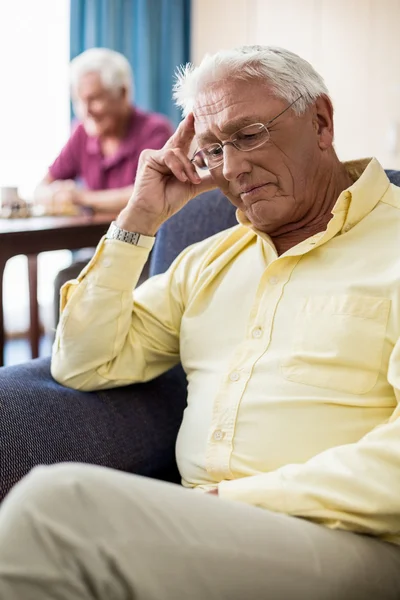 Senior sitting on a couch — Stock Photo, Image