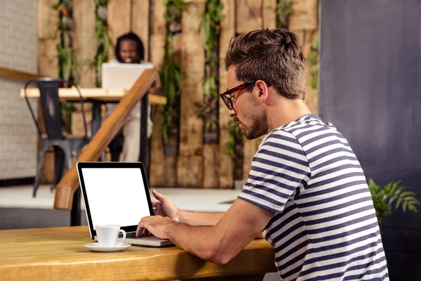 Man sitting at table using laptop — Stock Photo, Image