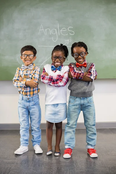 Drie schoolkinderen tegen schoolbord — Stockfoto