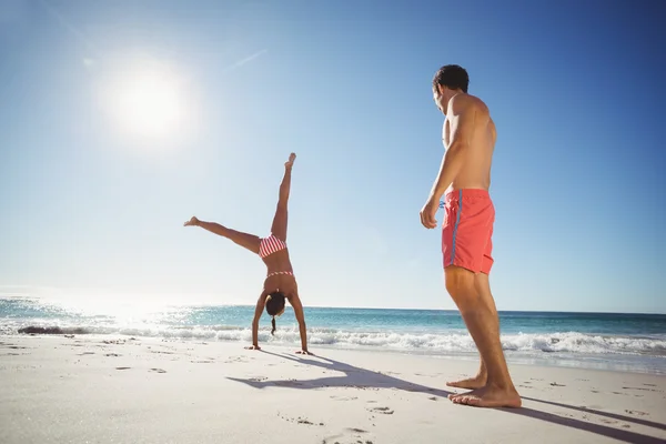 Femme effectuant un saut périlleux sur la plage — Photo