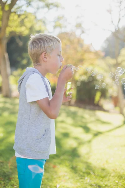 Ung pojke blåser bubblor genom bubblan trollspö — Stockfoto