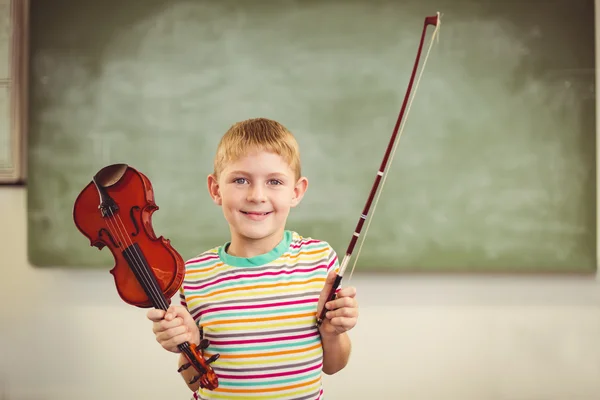 Schoolboy holding violin in classroom — Stock Photo, Image