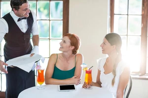 Serveur servant un cocktail aux femmes au restaurant — Photo