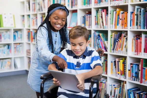 Schülerin steht mit Schüler im Rollstuhl — Stockfoto