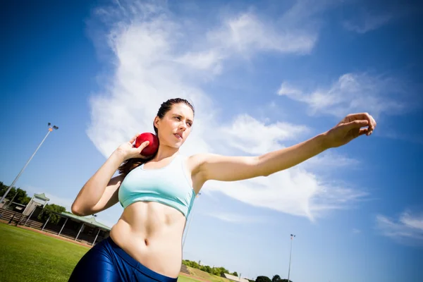 Vrouwelijke atleet voorbereiding kogelstoten bal te gooien — Stockfoto