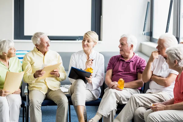 Seniorer och sjuksköterska innehar dokument — Stockfoto