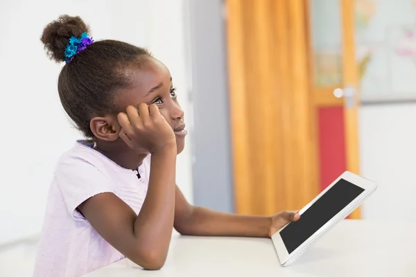 Nachdenkliche Schülerin mit Tablet im Klassenzimmer — Stockfoto