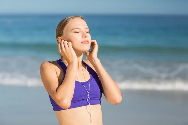 Mujer escuchando música mientras hace ejercicio —  Fotos de Stock