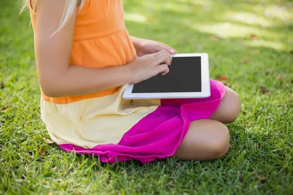 Ung pige ved hjælp af digital tablet i parken - Stock-foto